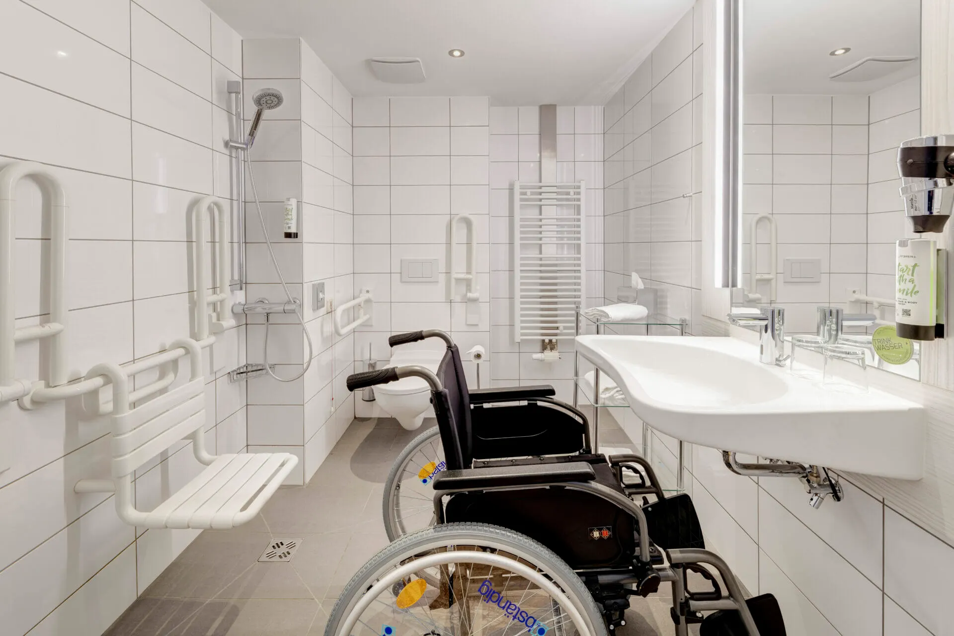 Barrierefreies Bad mit bodengleicher Dusche, Klappsitz und Haltegriffen